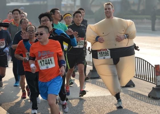 본문 이미지 - 1일 중국 상하이 마라톤 대회에서 한 참가자가 스모 선수 모양의 옷을 입고 달리고  있다. 이번 대회에는 약 3만명이 참가했다. © AFP=뉴스1  