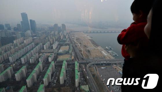 본문 이미지 - 2일 오후 서울 영등포구 63시티에서 한 가족이 서울 시내를 바라보고 있다. 기상청은 2일 오후부터 중국발 스모그가 국내로 유입되면서 미세먼지 농도가 짙어질 것으로 예보했다. © News1 최영호 기자