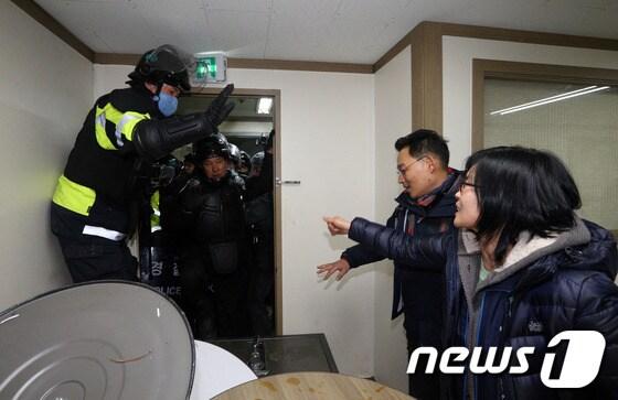 본문 이미지 - 경찰이 철도노조 지도부 검거에 나선 22일 오후 서울 중구 정동 민주노총에서 경찰 관계자가 문을 뜯고 진입하자 노조 관계자들이 반발하고 있다. © News1 사진공동취재단