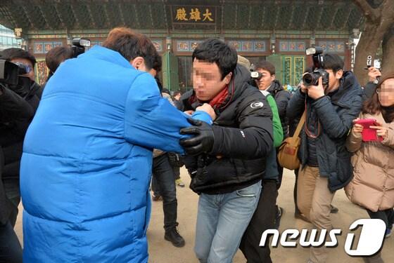 본문 이미지 - 철도노조 지지자들이 25일 오후 불법파업 혐의로 체포영장이 발부된 박태만 철도노조 수석부위원장이 은신 중인 서울 종로구 조계사에서 사복경찰&#40;가운데 검은옷&#41;을 밖으로 끌어내고 있다. © News1 박세연 기자