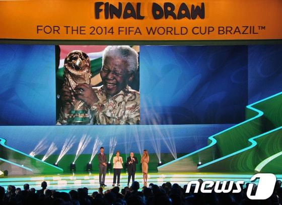 본문 이미지 - 지난 7일 오전(한국시간) 브라질  바이아주 코스타 도 사우이페에서 열린 '2014 브라질 월드컵 조추첨식'에서 제프 블래터 국제축구연맹(FIFA) 회장과 지우마 호세프 브라질 대통령이 타계한 넬슨 만델라 전 남아프리카공화국 대통령을 애도하고 있다.AFP=NEWS1 © News1   (AFP=NEWS1)