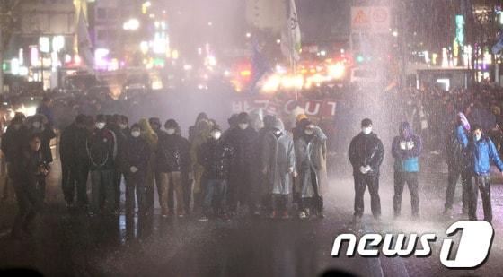 본문 이미지 - 한국진보연대, 민주노총을 비롯한 100여개 노동조합과 시민사회단체 참가자들이 7일 오후 서울역광장에서 '박근혜 정부 규탄 비상시국대회'를 마치고 도심으로 행진을 벌이다 종로3가에서 인도로 물러날 것을 요구하는 경찰이 쏜 물대포를 맞고 있다. 2013.12.7/뉴스1 © News1   한재호 기자