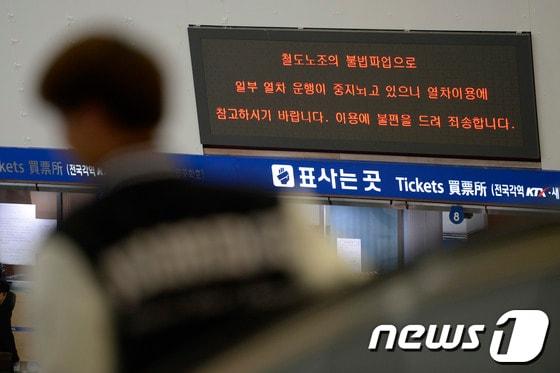 본문 이미지 - 전국철도노동조합이 파업을 시작한 9일 오후 서울역을 찾은 시민 너머로 열차 운행에 차질을 빚고 있다는 내용의 전광판이 보이고 있다. © News1 민경석 기자