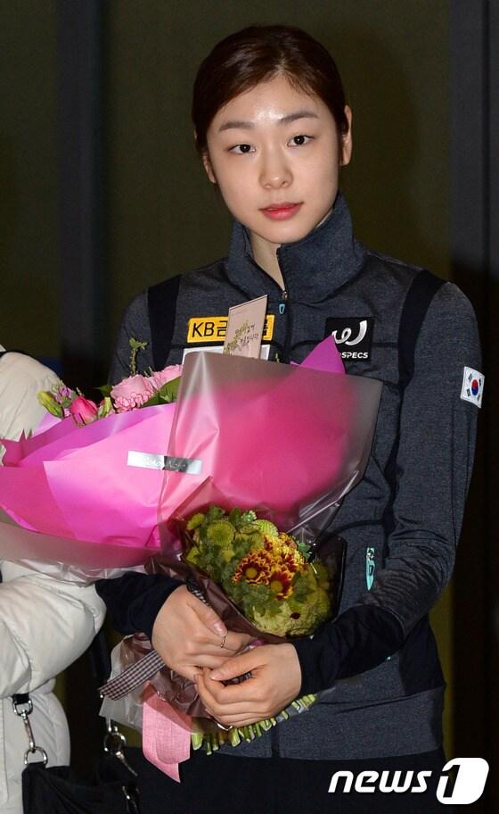 본문 이미지 - 크로아티아에서 열린 '골든 스핀 오브 자그레브' 대회 여자 싱글에서 금메달을 목에 건 '피겨 여왕' 김연아가 9일 인천공항을 통해 입국, 꽃다발을 받아들고 있다.김연아는 부상을 딛고 출전한 이번 대회에서 204.49점으로 우승을 차지, 2014 소치동계올림픽 금메달 전망을 밝혔다. 2013.12.9/뉴스1 © News1   정회성 기자