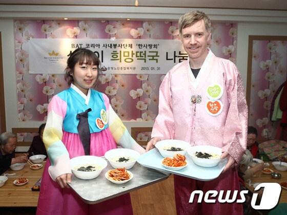 본문 이미지 - BAT 코리아의 한사랑회 회원들이 경로당에서 어르신들께 떡국을 끓여 대접하기에 앞서 포즈를 취하고 있다.(BAT 코리아 제공)© News1 