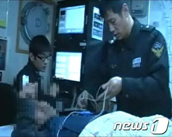 본문 이미지 - 해경 응급구조사가 손가락이 절단된 선원을 육지병원 전문의의 지시에 따라 치료하고 있다./사진제공=포항해양경찰서© News1 