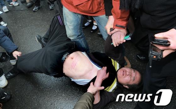 본문 이미지 - 22일 서울 중학동 일본대사관 앞에서 한 남성이 일본 정부를 규탄하며 자해를 시도하고 있다. 2013.2.22/뉴스1 © News1 오대일 기자