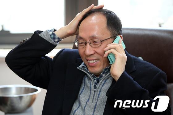 본문 이미지 - 공정거래위원장에 내정된 한만수 이화여대 법학과 교수가 14일 이화여대 법학관 사무실에서 축하 전화를 받으며 웃고 있다./뉴스1 © News1 이광호 기자