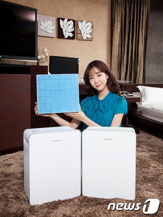 본문 이미지 - 삼성전자 모델이 봄철 황사에 대비할 수 있는 혁신 제품인 '삼성전자 2013년형 공기청정기'와 미세먼지를 99.97%까지 잡아내는 '트루헤파필터'를 소개하고 있다.(사진=삼성전자) © News1  