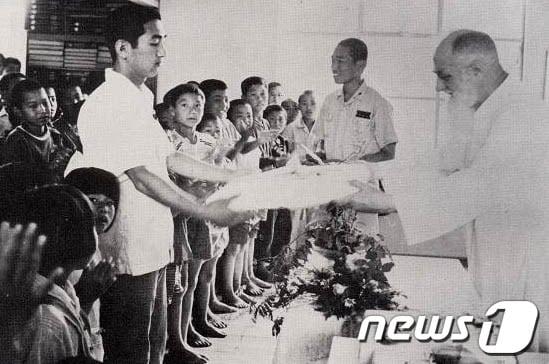 본문 이미지 - 남대영 신부가 고아들에게 선물을 전달하고 있는 모습./사진제공=포항시© News1 