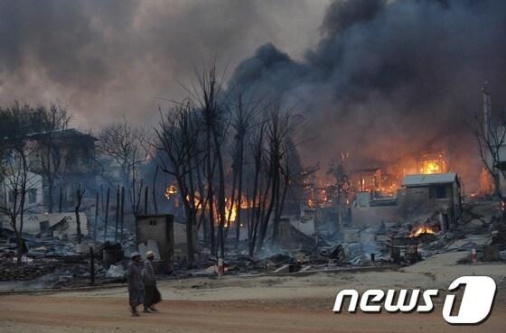 본문 이미지 - 21일(현지시간) 미얀마 메이크틸라시에 소요 사태가 계속되면서 주택들이 불타고 있다. © AFP=News1 