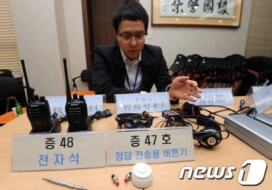 본문 이미지 - 경찰이 지난달 17일 오전 서울 관악경찰서에서 토익·텝스 부정시험에 사용된 단추 카메라를 비롯한 첨단 장비를 공개하고 있다. © News1 손형주 기자