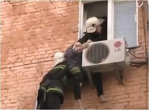 본문 이미지 - 우크라이나에 살고 있는 97세 노인이 청소를 하다가 창문으로 떨어졌지만 에어컨 실외기에 매달려 구조되고 있다.(유튜브)© News1  