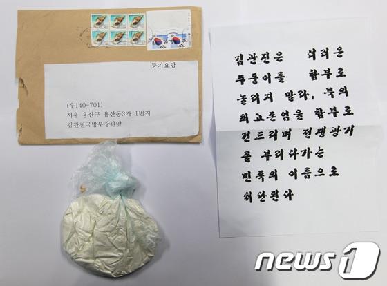 본문 이미지 - 지난달 23일 김관진 국방부 장관 앞으로 배달된 소포에서 나온 백색가루와 김 장관 협박편지. 백색가루는 분석을 실시한 결과 밀가루로 밝혀졌다.(국방부 제공) © News1 