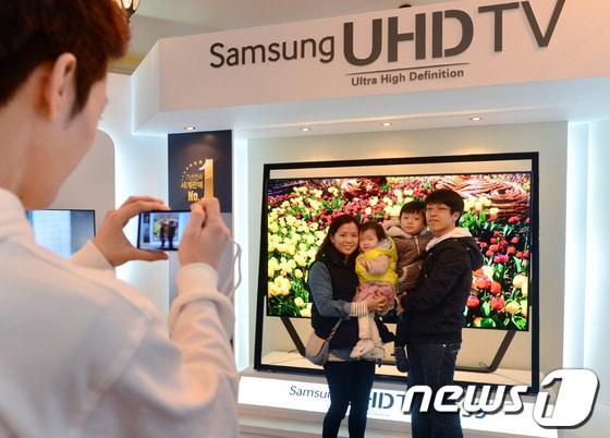 본문 이미지 - 지난달 6일 경기 용인 에버랜드에서 열린 삼성전자 S데이 스마트TV 가족사진 갤러리 행사장에서 관람객들이 85형 UHD TV의 튤립사진을 배경으로 기념 촬영을 하고 있다.(삼성전자 제공) 2013.4.7/뉴스1 © News1   