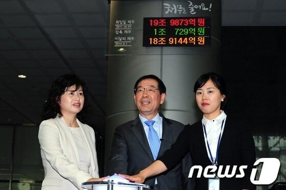 본문 이미지 - 박원순 서울시장이 서울시청 로비에 설치된 채무현황판 점등식에서 윤성희 주민참여예산위원(왼쪽), 김수희 채무현황 주무관과 함께 점등하고 있다. 2013.5.13/뉴스1 © News1   한재호 기자
