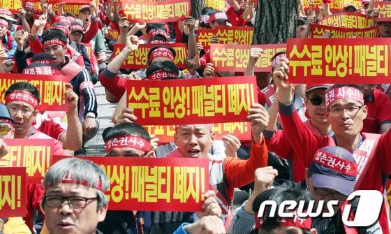 본문 이미지 - 13일 오후 서울 여의도 산업은행 앞에서 열린 대한통운 택배노동자 생존권 쟁취 결의대회에서 참석자들이 수수료 인상과 패널티 폐지를 촉구하고 있다. 2013.5.13/뉴스1 © News1   허경 기자