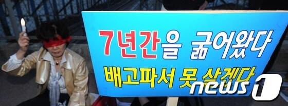 본문 이미지 - 13일 오후 서울 용산구 새남터성당 고가도로 위에서 열린 용산개발사업 정상화를 위한 촉구집회에서 한 참가자가 촛불을 들고 있다. 이번 집회는 청산절차가 진행된 이후 처음 실시됐다. 2013.5.13/뉴스1 © News1   박지혜 기자