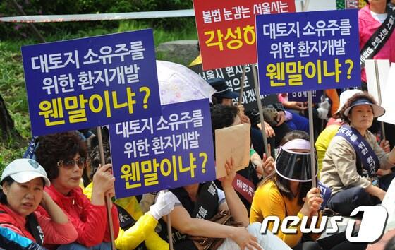 본문 이미지 - 15일 오후 서울 코엑스 앞에서 강남구 주민자치위원회 회원들이 서울시의 구룡마을 일부환지 개발방식 변경에 반대하는 집회를 열고 구호를 외치고 있다. 이들은 