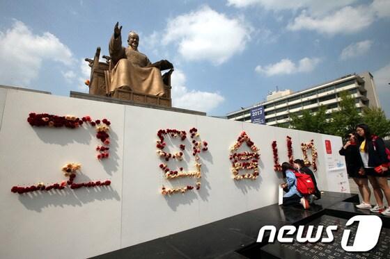 본문 이미지 - 15일 오후 서울 광화문광장에서 열린 '세종대왕 나신날' 큰잔치에서 시민들이 세종대왕 동상 앞에 마련된 '고맙습니다'라는 글 위에 카네이션을 꽂고 있다. © News1 이광호 기자