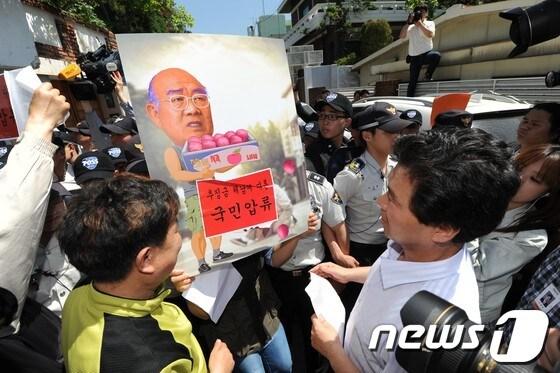 본문 이미지 - 참여연대, 민주노총, 민변 등이 지난 16일 서울 연희동 전두환 전 대통령 자택 앞에서추징금 체납에 대한 국민압류의 뜻으로 차압딱지를 붙이고 있다. 2013.5.16/뉴스1 © News1 윤선미 인턴기자
