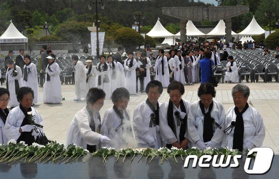 본문 이미지 - 5·18민중항쟁 제33주년 추모제가 열린 17일 오전 광주 북구 운정동 국립 5·18민주묘지에서 유가족들이 5·18 민중항쟁 추모탑 앞에서 5월 영령들의 넋을 기리며 헌화·분향하고 있다. 2013.5.17/뉴스1 © News1 정회성 