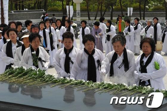 본문 이미지 - 5·18민중항쟁 제33주년 추모제가 열린 17일 광주 북구 운정동 국립 5·18민주묘지에서 유가족들이 추모탑 앞에서 5월 영령들의 넋을 기리며 헌화·분향하고 있다. /뉴스1 © News1 정회성 