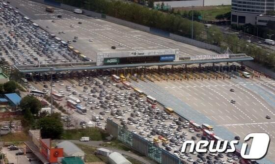 본문 이미지 - 석가탄신일 황금연휴의 첫 날인 17일 오전 경부고속도로 하행선 서울톨게이트에서 차량들이 몰려 정체현상을 보이고 있다.(항공협조=경기청항공대 기장 경위 김동섭, 부기장 경위 장현) © News1 