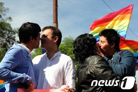 본문 이미지 - 파라과이 아순시온의 아르마스 광장에서 17일(현지시간) '국제 성소수자 혐오 반대의 날'을 맞아 동성연애자들이 키스를 하는 퍼포먼스를 펼치고 있다. '국제 성소수자 혐오 반대의 날'은 지난 1990년 5월 17일 세계보건기구가 동성애를 정신질환 목록에서 삭제한 것을  기념하는 날이다. © AFP=News1  