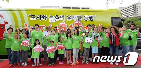 본문 이미지 - '해피 버스데이(Happy Busday)' 출정식 참가자들이 19일 오전 서울 용산구 용산가족공원 주차장에서 포토타임을 갖고 있다. 농림축산식품부가 주최한 해피 버스데이(Happy Busday)는 도시민들이 농축산물의 생산과 가공과정을 체험하는 농촌 여행 프로그램으로, 이를 통해 우리 농촌의 가치를 더 알자는 취지로 기획 되었다. 2013.5.19/뉴스1 © News1   박철중 기자