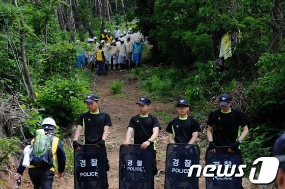 본문 이미지 - 한전이 경남 밀양지역 765㎸ 송전탑 공사를 재개한 20일 오전 밀양 부북면 위양리 평밭마을 127 송전탑 공사현장에 한전 직원과 경찰이 길을 막아서고 있다. 2013.5.20/뉴스1 © News1 전혜원 기자