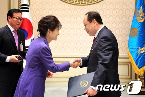 본문 이미지 - 청와대에서 열린 2013 중소기업 유공자 포상에서 박근혜 대통령(왼쪽)이 토니모리 배해동 회장(오른쪽)에게 시상하고 있다. © News1  