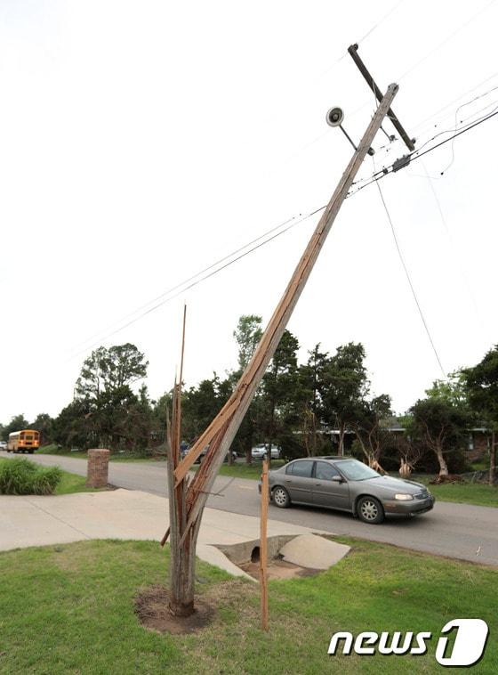 본문 이미지 - 토네이도가 휩쓸고 간 미국 오클라호마주 쇼니에서 20일(현지시간) 전봇대가 꺾여있다. 19일 발생한 토네이도로 현재 10명 이상이 숨지고 수십명이 부상당했다. © AFP=News1  