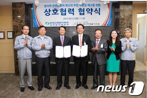 본문 이미지 - 이영일 고리본부장(왼쪽 세 번째)과 정승윤 대표(왼쪽 네 번째)가 협약서를 교환하고 있다./사진제공=고리원자력본부© News1 