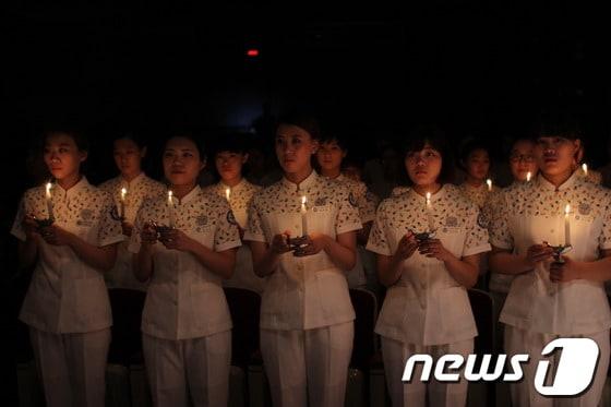 본문 이미지 - 고신대 간호학과 3학년 학생들이 22일 나이팅게일 선서식에서 촛불의식을 하고 있다.(고신대복음병원 제공)© News1 