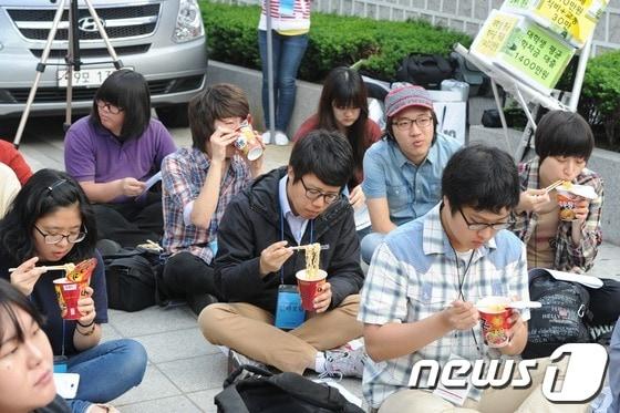 본문 이미지 - 알바연대 회원들이 23일 오전 경총포럼이 열리고 있는 서울 소공동 조선호텔 앞에서 컵라면으로 아침을 먹고 있다. 2013.5.23/뉴스1 © News1 허경 기자