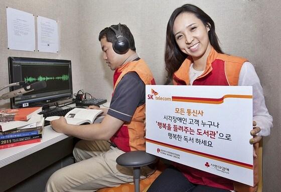 본문 이미지 - SK텔레콤 구성원들이 시각장애인 전용 음성 콘텐츠 서비스인 ‘행복을 들려주는 도서관’을 위해 음성 도서를 녹음하는 행복동행 자원봉사 활동을 하고 있다. © News1  