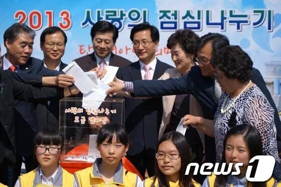본문 이미지 - 22일 오후 2시 강릉시청 임영대종각 앞에서 진행된 사랑의 점심 나누기 행사에 최명희 강릉시장(왼쪽에서 4번째)이 후원금을 넣고있다 © News1  