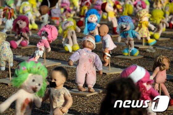 본문 이미지 - 이스라엘 텔아비브의 라빈광장에서 23일(현지시간) 아동학대에 대해 반대하는 퍼포먼스의 일환으로 멍이 들고 붕대에 감긴 인형들이 전시돼있다. © AFP=News1  
