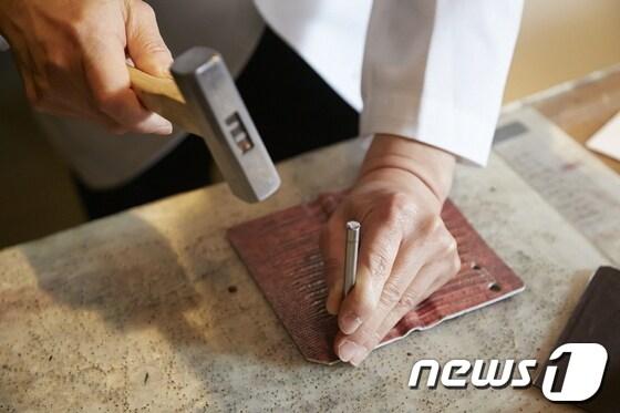 본문 이미지 - 시몬느의 장인이 팬택의 베가 아이언 가죽 케이스를 제작하고 있다.(팬택 제공)© News1  