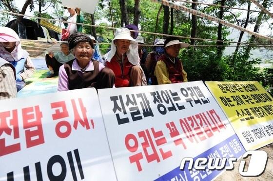 본문 이미지 - 한전이 밀양지역 765kV 송전탑 공사를 닷새째 이어간 24일 오전 밀양 부북면 평밭마을 입구에 마을 주민들이 피켓을 들고 농성을 이어나가고 있다. 2013.5.24/뉴스1 © News1 전혜원 기자