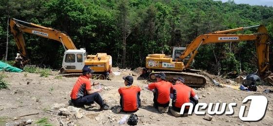 본문 이미지 - 한전이 밀양지역 765kV 송전탑 공사를 닷새째 이어간 24일 오전 밀양 단장면 바드리 송전탑 공사현장에서 주민들이 굴착기 옆에서 않아 농성을 벌여 공사가 중단돼 있다. © News1 전혜원 기자