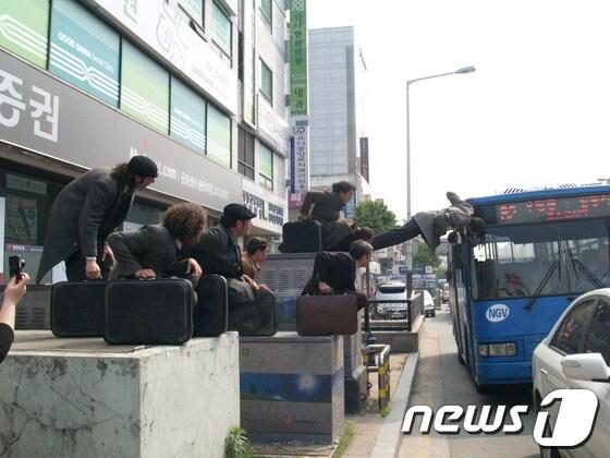 본문 이미지 - 공연단이 버스에 매달려 있다 © News1 윤창완 기자 