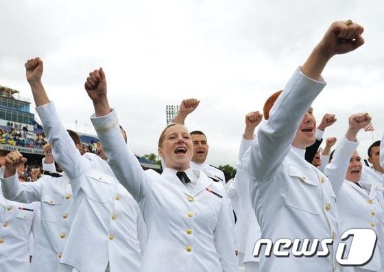 본문 이미지 - 미국 매릴랜드 아나폴리스 소재의 해군사관학교에서 24일(현지시간) 졸업생들이 교가를 부른 뒤 환호하고 있다. © AFP=News1  