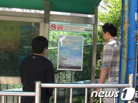 본문 이미지 - 해운대구 반송2동 남흥아파트 정류장에 게시된 '시화'를 주민들이 읽고 있다.(해운대구 제공)© News1 
