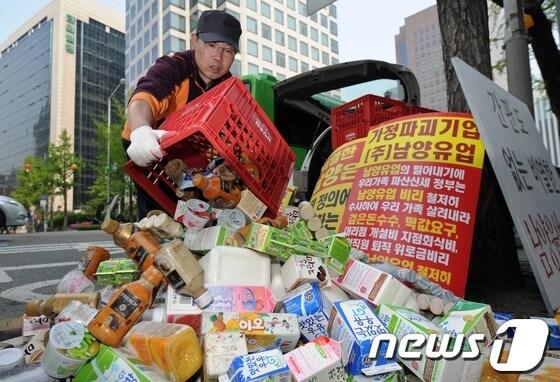 본문 이미지 - 6일 오전 서울 남대문로 남양유업 본사 앞에서 남양유업 대리점 피해자 협의회 회원들이 남양유업 제품을 길에 쏟고 있다. 2013.5.6/뉴스1 © News1 손형주 기자