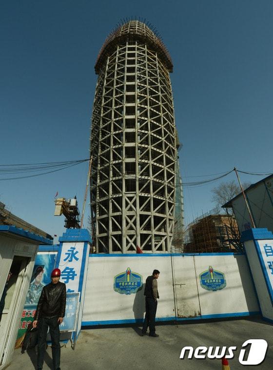 본문 이미지 - 중국 베이징에서 인민일보의 본사 건물이 공사 중에 있다. 중국의 인기 소셜네트워크서비스(SNS)인 '웨이보'에서는 이 건물의 모양이 남자의 성기를 닮았다고 논란이 된 바 있다. AFP에 따르면 현재 웨이보 검색창에서는 '인민일보'와 '건물'을 함께 검색할 경우 '검색 불가' 화면이 뜬다. © AFP=News1 