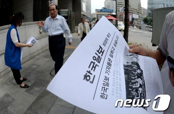 본문 이미지 - 한국일보에 용역을 동원한 편집국 봉쇄와 기사 집배신시스템 폐쇄라는 한국 언론사상 초유의 사태가 발생한 가운데 지난 17일  서울 중구 남대문로 2가 본사 앞에서 전국언론노동조합 한국일보지부 기자들이 비상대책위 특보를 시민들에게 나눠주고 있다. 한국일보 노동조합 비상대책위원회에 따르면 사측은 지난 15일 오후 6시20분쯤 서울 중구 남대문로 한진빌딩 15층 편집국을 폐쇄하고 당시 편집국 안에서 근무 중이던 당직기자를 편집국 밖으로 몰아낸 후 '근로제공 확약서'라는 문서에 서명하도록 요구했다고 밝혔다. 2013.6.17/뉴스1 © News1 박정호 기자