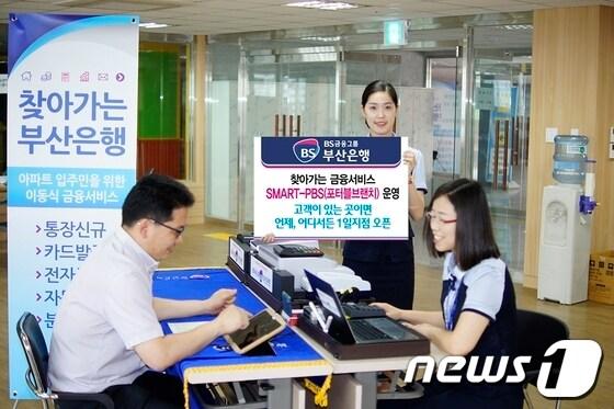 본문 이미지 - 부산은행 직원이 17일 포터블 브랜치 단말기를 이용해 금융 서비스를 하고 있다.(부산은행 제공)© News1 