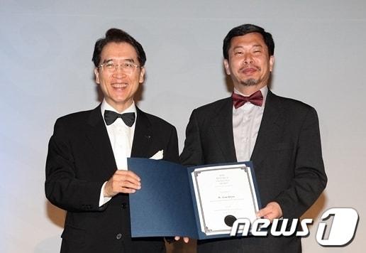 본문 이미지 - 17일 저녁 서울 그랜드하얏트호텔에서 열린 세계보험협회(IIS) 연차총회 시상식에서 교보생명 신창재 회장(왼쪽)이 ‘신용호세계보험학술대상’ 수상자로 선정된 美 세인트존스대 권욱진 교수에게 상패를 수여하고 있다.© News1  